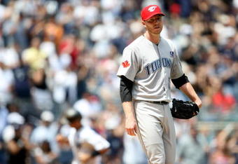 NEW YORK - JULY 04:  Roy Halladay #32 of the Toronto Blue Jays reacts after Jorge Posada #20 of the New York Yankees hit a home run in the fourth inning on July 4, 2009 at Yankee Stadium in the Bronx borough of New York City.  (Photo by Nick Laham/Getty Images)