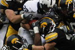 IOWA CITY, IA - NOVEMBER 8:  Defenders Matt Kroul #53, Pat Angerer #43 and Jeremiah Hunter #42 of the Iowa Hawkeyes tackle Evan Royster #22 of the Penn State Nittany Lions as he rushes for yards in the second quarter of play at Kinnick Stadium on November 8, 2008 in Iowa City, Iowa. Iowa defeated Penn State 24-23. (Photo by David K Purdy/Getty Images)