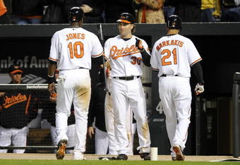 BALTIMORE - APRIL 06:  Adam Jones #10 and Nick Markakis #21 of the Baltimore Orioles are congratulated by Luke Scott #30 after scoring in the eighth inning against the New York Yankees during opening day on April 6, 2009 at Camden Yards in Baltimore, Maryland.  (Photo by Greg Fiume/Getty Images)