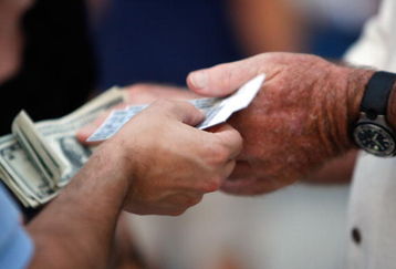 ST PETERSBURG, FL - OCTOBER 22:  A fan holds tickets and another holds money before the Philadelphia Phillies take on the Tampa Bay Rays during game one of the 2008 MLB World Series on October 22, 2008 at Tropicana Field in St. Petersburg, Florida.  (Photo by Jamie Squire/Getty Images)