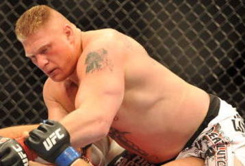 LAS VEGAS - JULY 11:  Brock Lesnar holds down Frank Mir during their heavyweight title bout during UFC 100 on July 11, 2009 in Las Vegas, Nevada. Lesnar defeated Mir by a second round knockout.  (Photo by Jon Kopaloff/Getty Images)