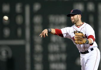 BOSTON - JULY 07:  Dustin Pedroia #15 of the Boston Red Sox sends the ball to first on a hit from Adam Kennedy of the Oakland Athletics on July 7, 2009 at Fenway Park in Boston, Massachusetts.  (Photo by Elsa/Getty Images)