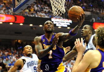 ORLANDO, FL - JUNE 14:  Lamar Odom #7 of the Los Angeles Lakers goes up for a shot between Rashard Lewis #9 and Dwight Howard #12 of the Orlando Magic in the second quarter of Game Five of the 2009 NBA Finals on June 14, 2009 at Amway Arena in Orlando, Florida.  NOTE TO USER:  User expressly acknowledges and agrees that, by downloading and or using this photograph, User is consenting to the terms and conditions of the Getty Images License Agreement.  (Photo by Ronald Martinez/Getty Images)