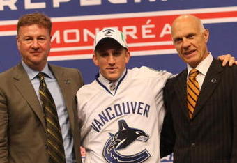 MONTREAL - JUNE 26:  Vancouver Canucks GM Mike Gillis, draft pick Jordan Schroeder and VP Player Personnel & Assistant GM Lorne Henning pose during the first round of the 2009 NHL Entry Draft at the Bell Centre on June 26, 2009 in Montreal, Quebec, Canada. (Photo by Bruce Bennett/Getty Images)