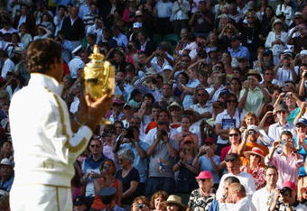WIMBLEDON, ENGLAND - JULY 05:  Roger Federer of Switzerland celebrates victory with the trophy after the men's singles final match against Andy Roddick of USA on Day Thirteen of the Wimbledon Lawn Tennis Championships at the All England Lawn Tennis and Croquet Club on July 5, 2009 in London, England. Federer won 5-7, 7-6, 7-6, 3-6, 16-14.  (Photo by Clive Brunskill/Getty Images)