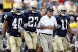SOUTH BEND, IN - SEPTEMBER 13:  Former head coach Lou Holtz of the Notre Dame Fighting Irish walks out for the coin toss with David Grimes #11, David Bruton #27 and Maurice Crum #40 prior to playing the Michigan Wolverines on September 13, 2008 at Notre Dame Stadium in South Bend, Indiana.  (Photo by Gregory Shamus/Getty Images)