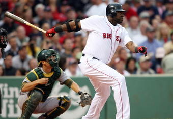 BOSTON - JULY 07:  David Ortiz #34 of the Boston Red Sox hits a single as Kurt Suzuki #8 of the Oakland Athletics defends on July 7, 2009 at Fenway Park in Boston, Massachusetts.  (Photo by Elsa/Getty Images)