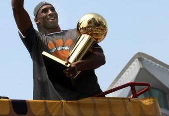 LOS ANGELES, CA - JUNE 17:  Kobe Bryant #24 holds the Larry O'Brien trophy and waves to the crowd from the top of a double decker bus at the start of the Los Angeles Lakers NBA championship victory parade outside the Staples Center on June 17, 2009 in Los Angeles, California.  (Photo by Stephen Dunn/Getty Images)