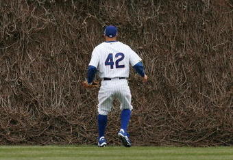 CHICAGO - APRIL 15: Reed Johnson of the Chicago Cubs, wearing a #42 jersey on Jackie Robinson Day, watches as fans try to catch a home run ball hit by Seth Smith of the Colorado Rockies on April 15, 2009 at Wrigley Field in Chicago, Illinois. The Rockies defeated the Cubs 5-2. (Photo by Jonathan Daniel/Getty Images) 