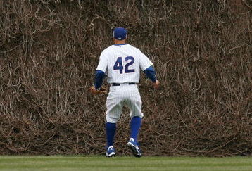 CHICAGO - APRIL 15: Reed Johnson of the Chicago Cubs, wearing a #42 jersey on Jackie Robinson Day, watches as fans try to catch a home run ball hit by Seth Smith of the Colorado Rockies on April 15, 2009 at Wrigley Field in Chicago, Illinois. The Rockies defeated the Cubs 5-2. (Photo by Jonathan Daniel/Getty Images) 