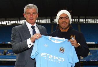 MANCHESTER, ENGLAND - JULY 14:  Mark Hughes, manager of Manchester City, poses with Carlos Tevez after he signed for Manchester City at City of Manchester Stadium on July 14, 2009 in Manchester, England.  (Photo by Matthew Lewis/Getty Images)