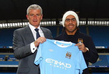 MANCHESTER, ENGLAND - JULY 14:  Mark Hughes, manager of Manchester City, poses with Carlos Tevez after he signed for Manchester City at City of Manchester Stadium on July 14, 2009 in Manchester, England.  (Photo by Matthew Lewis/Getty Images)
