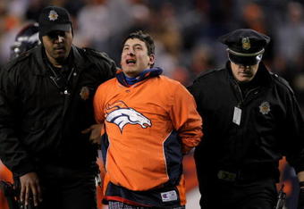 DENVER - NOVEMBER 23:  A fan is forcibly removed from the field after running onto the field during the fourth quarter as the Oakland Raiders faced the Denver Broncos during week 12 NFL action at Invesco Field at Mile High on November 23, 2008 in Denver, Colorado. The Raiders defeated the Broncos 31-10.  (Photo by Doug Pensinger/Getty Images)