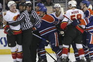 EDMONTON, AB - MARCH 3: Linesman Jay Sharrers #57 seperates Dion Phaneuf #3 (far left) of the Calgary Flames from Steve Staios #24 (left of center) of the Edmonton Oilers as other players look to get involved during third period NHL action at Rexall Place on March 3, 2007, in Edmonton, Alberta, Canada. (Photo by Tim Smith/Getty Images)