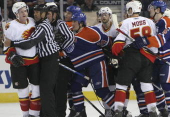 EDMONTON, AB - MARCH 3: Linesman Jay Sharrers #57 seperates Dion Phaneuf #3 (far left) of the Calgary Flames from Steve Staios #24 (left of center) of the Edmonton Oilers as other players look to get involved during third period NHL action at Rexall Place on March 3, 2007, in Edmonton, Alberta, Canada. (Photo by Tim Smith/Getty Images)
