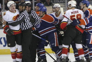 EDMONTON, AB - MARCH 3: Linesman Jay Sharrers #57 seperates Dion Phaneuf #3 (far left) of the Calgary Flames from Steve Staios #24 (left of center) of the Edmonton Oilers as other players look to get involved during third period NHL action at Rexall Place on March 3, 2007, in Edmonton, Alberta, Canada. (Photo by Tim Smith/Getty Images)