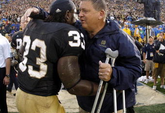 SOUTH BEND, IN - SEPTEMBER 13:  Head coach Charlie Weis of the Notre Dame Fighting Irish is congratulated by Robert Hughes #33 during the final seconds of their 35-17 victory over the Michigan Wolverines on September 13, 2008 at Notre Dame Stadium in South Bend, Indiana.  (Photo by Gregory Shamus/Getty Images)