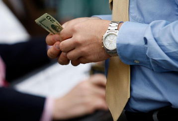 LOUISVILLE, KY - MAY 02:  A race fan holds money during the 135th running of the Kentucky Derby on May 2, 2009 at Churchill Downs in Louisville, Kentucky.  (Photo by Jamie Squire/Getty Images)