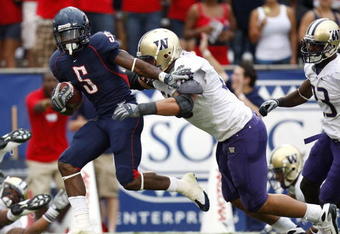 TUCSON, AZ - OCTOBER 04:  Nic Grigsby #5 of the Arizona Wildcats tries to escape the tackle of Daniel Te'o-Nesheim #66 of the Washington Huskies during a first quarter run on October 4, 2008 at Arizona Stadium in Tucson, Arizona.  (Photo by Gregory Shamus/Getty Images)