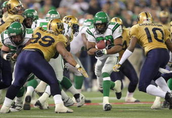 TORONTO - NOVEMBER 25:  Wes Cates #20 of the Saskatchewan Rough Riders tries to split the defense of Jerome Haywood #99 and Ike Charlton #10 of the Winnipeg Blue Bombers during the fourth quarter in the 95th Grey Cup on November 25, 2007 at the Rogers Centre in Toronto, Ontario, Canada.  The Rough Riders won 23-19.  (Photo by Harry How/Getty Images)