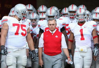 LOS ANGELES, CA - SEPTEMBER 13:  Head coach Jim Tressel of the Ohio State Buckeyes leads teammates Alex Boone #75 and Marcus Freeman #1 out onto the field before the college football game against the USC Trojans at Los Angeles Memorial Coliseum on September 13, 2008 in Los Angeles, California. The Trojans defeated the Buckeyes 35-3.  (Photo by Christian Petersen/Getty Images)