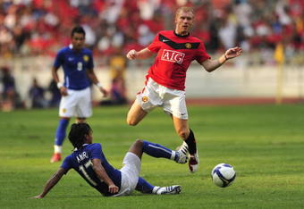 KUALA LUMPUR, MALAYSIA - JULY 18: Paul Scholes of Manchester United is tackled by Mohd Amri Yahyah of Malaysia XI during the pre-season friendly match between Manchester United and Malaysia XI at the Bukit Jalil National Stadium on July 18, 2009 in Kuala Lumpur, Malaysia. (Photo by Stanley Chou/Getty Images)