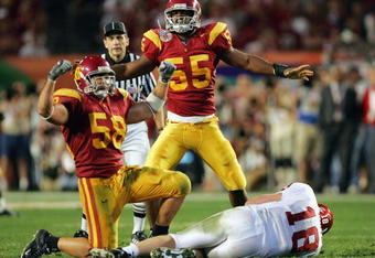 MIAMI - JANUARY 4:  Keith Rivers #55 and Lofa Tatupu #58 of the USC Trojans celebrate after sacking Jason White #18 of the Oklahoma Sooners in the third quarter during the FedEx Orange Bowl 2005 National Championship on January 4, 2005 at Pro Player Stadium in Miami, Florida.  (Photo by Jamie Squire/Getty Images)