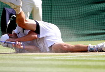 WIMBLEDON, ENGLAND - JULY 05:  Andy Roddick of USA tumbles during the men's singles final match against Roger Federer of Switzerland on Day Thirteen of the Wimbledon Lawn Tennis Championships at the All England Lawn Tennis and Croquet Club on July 5, 2009 in London, England.  (Photo by Clive Brunskill/Getty Images)