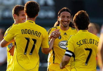 KANSAS CITY, KS - JUNE 06:  Rauwshan McKenzie #12, Pat Noonan #11, and Gino Padula #4 of the Columbus Crew congratulate Guillermo Schelotto #7 after Schelotto scored during the first half of the game against the Kansas City Wizards at CommunityAmerica Ballpark on June 6, 2009 in Kansas City, Kansas.  (Photo by Jamie Squire/Getty Images)