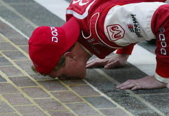 INDIANAPOLIS - AUGUST 4:  Bill Elliott, driver of the #9 Evernham Motorsports Dodge intrepid R\T, kisses the bricks after winning the NASCAR Winston Cup Brickyard 400 on  August 4, 2002 during  at Indianapolis Motor Speedway in Indianapolis, Indiana. (Photo by Jonathan Ferrey/Getty Images)