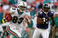 MIAMI - DECEMBER 16: Wide receiver Greg Camarillo #83 of the Miami Dolphins breaks away from defensive back Jamaine Winborne #28 of the Baltimore Ravens for the game winning touchdown in overtime at Dolphin Stadium on December 16, 2007 in Miami, Florida. The Dolphins defeated the Ravens 22-16 for their first victory of the year. (Photo by Doug Benc/Getty Images)