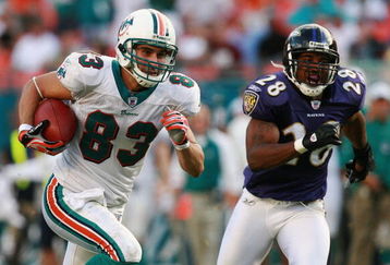 MIAMI - DECEMBER 16:  Wide receiver Greg Camarillo #83 of the Miami Dolphins breaks away from defensive back Jamaine Winborne #28 of the Baltimore Ravens for the game winning touchdown in overtime at Dolphin Stadium on December 16, 2007 in Miami, Florida. The Dolphins defeated the Ravens 22-16 for their first victory of the year.  (Photo by Doug Benc/Getty Images)