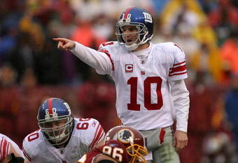 LANDOVER, MD - NOVEMBER 30:  Eli Manning #10 of the New York Giants runs points to his team against the Washington Redskins during their game at FedEx Field on November 30, 2008 in Landover, Maryland.  (Photo by Streeter Lecka/Getty Images)