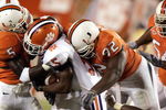 MIAMI - NOVEMBER 6: Running back Yusef Kelly #5 of the Clemson Tigers is tackled by defensive back Greg Threat #5 and defensive linemen Orien Harris #92 of the Miami Hurricanes on November 6, 2004 at the Orange Bowl in Miami, Florida. (Photo by Eliot J. Schechter/Getty Images)