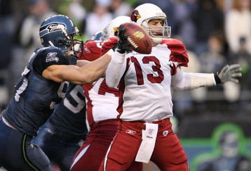 SEATTLE - DECEMBER 9:  Quarterback Kurt Warner #13 of the Arizona Cardinals is sacked by Patrick Kerney #97 of the Seattle Seahawks at Qwest Field December 9, 2007 in Seattle, Washington. The Seahawks defeated the Cardinals 42-21. (Photo by Otto Greule Jr/Getty Images)