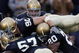SOUTH BEND, IN - OCTOBER 13:  Members of the Notre Dame Fighting Irish including John Ryan #90, Dwight Stephenson #57 and Terrail Lambert #20 are called for a penalty for excessive celebration as they jump on teammate Brian Smith after Smith intercepted a pass and ran for a touchdown against the Boston College Eagles on October 13, 2007 at Notre Dame Stadium in South Bend, Indiana. Boston College defeated Notre Dame 27-14.  (Photo by Jonathan Daniel/Getty Images)