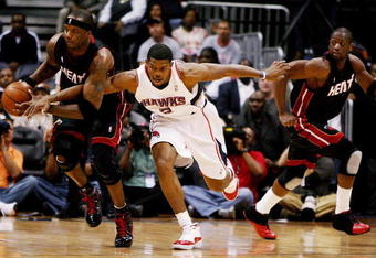 ATLANTA - APRIL 22:  Jermaine O'Neal #7 of the Miami Heat takes the ball away from Joe Johnson #2 of the Atlanta Hawks as Dwyane Wade #3 runs up-court during Game Two of the Eastern Conference Quarterfinals at Philips Arena on April 22, 2009 in Atlanta, Georgia. NOTE TO USER: User expressly acknowledges and agrees that, by downloading and/or using this Photograph, user is consenting to the terms and conditions of the Getty Images License Agreement.  (Photo by Doug Benc/Getty Images)
