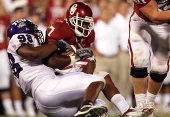 NORMAN, OK - SEPTEMBER 27:  Running back DeMarco Murray #7 of the Oklahoma Sooners is tackled by Jerry Hughes #98 of the TCU Horned Frogs at Memorial Stadium on September 27, 2008 in Norman, Oklahoma.  (Photo by Ronald Martinez/Getty Images)
