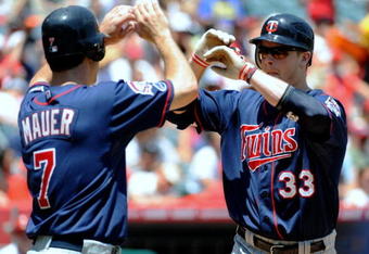 ANAHEIM, CA - JULY 26:  Justin Morneau #33 of the Minnesota Twins celebrates his two-run home run with teammate Joe Mauer #7 during the first inning against the Los Angeles Angels of Anaheim at Angels Stadium on July 26, 2009 in Anaheim, California. (Photo by Harry How/Getty Images)
