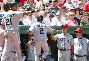 BOSTON - JULY 05:  Ken Griffey Jr #24, Franklin Gutierrez #21 and Kenji Johjima #2 of the Seattle Mariners are congratulated by teammates in the dugout after scoring in the fourth inning against the Boston Red Sox on July 5, 2009 at Fenway Park in Boston, Massachusetts.  (Photo by Elsa/Getty Images)