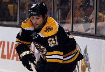 BOSTON - MAY 14:  Marc Savard #91 of the Boston Bruins takes the puck against the Carolina Hurricanes during Game Seven of the Eastern Conference Semifinal Round of the 2009 Stanley Cup Playoffs on May 14, 2009 at the TD Banknorth Garden in Boston, Massachusetts. The Hurricanes defeated the Bruins 3-2 in overtime. (Photo by Elsa/Getty Images)