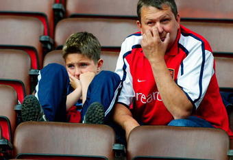 LONDON - MAY 4:  Arsenal fans look dejected after losing a match and title that seemed to be heading to them not to long ago after the FA Barclaycard Premiership match between Arsenal and Leeds United held on May 4, 2003 at Highbury, in London. Leeds United won the match 3-2. (Photo by Ben Radford/Getty Images)