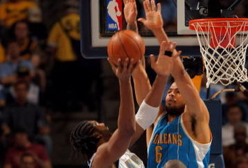 DENVER - APRIL 22:  Nene #31 of the Denver Nuggets tries to get off a shot against Tyson Chandler #6 of the New Orleans Hornets in Game Two of the Western Conference Quarterfinals during the 2009 NBA Playoffs at Pepsi Center on April 22, 2009 in Denver, Colorado. NOTE TO USER: User expressly acknowledges and agrees that, by downloading and or using this photograph, User is consenting to the terms and conditions of the Getty Images License Agreement.  (Photo by Doug Pensinger/Getty Images)