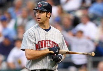 KANSAS CITY, MO - MAY 28:  Joe Mauer #7 of the Minnesota Twins walks off the field with his bat against the Kansas City Royals on May 28, 2008 at Kauffman Stadium in Kansas City, Missouri. (Photo by G. Newman Lowrance/Getty Images)