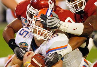 MIAMI - JANUARY 08:  Quarterback Tim Tebow #15 of the Florida Gators gets a facemask as he is sacked against the Oklahoma Sooners during the FedEx BCS National Championship Game at Dolphin Stadium on January 8, 2009 in Miami, Florida.  (Photo by Eliot J. Schechter/Getty Images