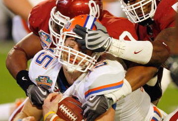 MIAMI - JANUARY 08:  Quarterback Tim Tebow #15 of the Florida Gators gets a facemask as he is sacked against the Oklahoma Sooners during the FedEx BCS National Championship Game at Dolphin Stadium on January 8, 2009 in Miami, Florida.  (Photo by Eliot J. Schechter/Getty Images