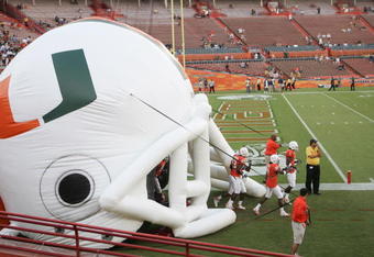 MIAMI - OCTOBER 14:  Miami Hurricanes players enter the field through a giant inflatable helmet before the game against the Florida International Panthers at the Orange Bowl on October 14, 2006 in Miami, Florida. Miami won 35-0.  (Photo by Marc Serota/Getty Images)