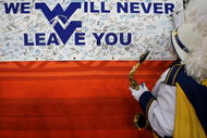 GLENDALE, AZ - JANUARY 02: A member of the West Virginia Mountaineers band signs a banner that was located behind the Mountaineers bench at the Tostito's Fiesta Bowl at University of Phoenix Stadium January 2, 2008 in Glendale, Arizona. (Photo by Doug Pensinger/Getty Images)