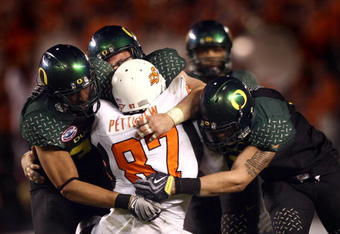 SAN DIEGO, CA - DECEMBER 30:   Tight End Brandon Pettigrew #87 of the Oklahoma State University Cowboys is tackled by the defense of the University of Oregon Ducks during the Ducks 42-31 win over the Cowboys in the Pacific Life Holiday Bowl at Qualcomm Stadium on December 30, 2008 in San Diego, California. (Photo by Donald Miralle/Getty Images)