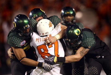 SAN DIEGO, CA - DECEMBER 30:   Tight End Brandon Pettigrew #87 of the Oklahoma State University Cowboys is tackled by the defense of the University of Oregon Ducks during the Ducks 42-31 win over the Cowboys in the Pacific Life Holiday Bowl at Qualcomm Stadium on December 30, 2008 in San Diego, California. (Photo by Donald Miralle/Getty Images)